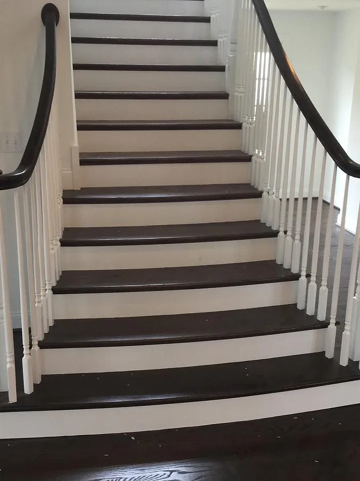 Staircase with dark hardwood treads, white risers and white balusters